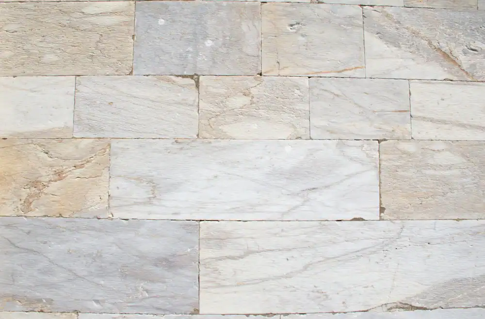 A close-up view of a wall made of rectangular, light-colored stone bricks with natural textures and subtle color variations, arranged in a horizontal pattern—ideal inspiration for marble restoration in Nassau & Suffolk County, NY.