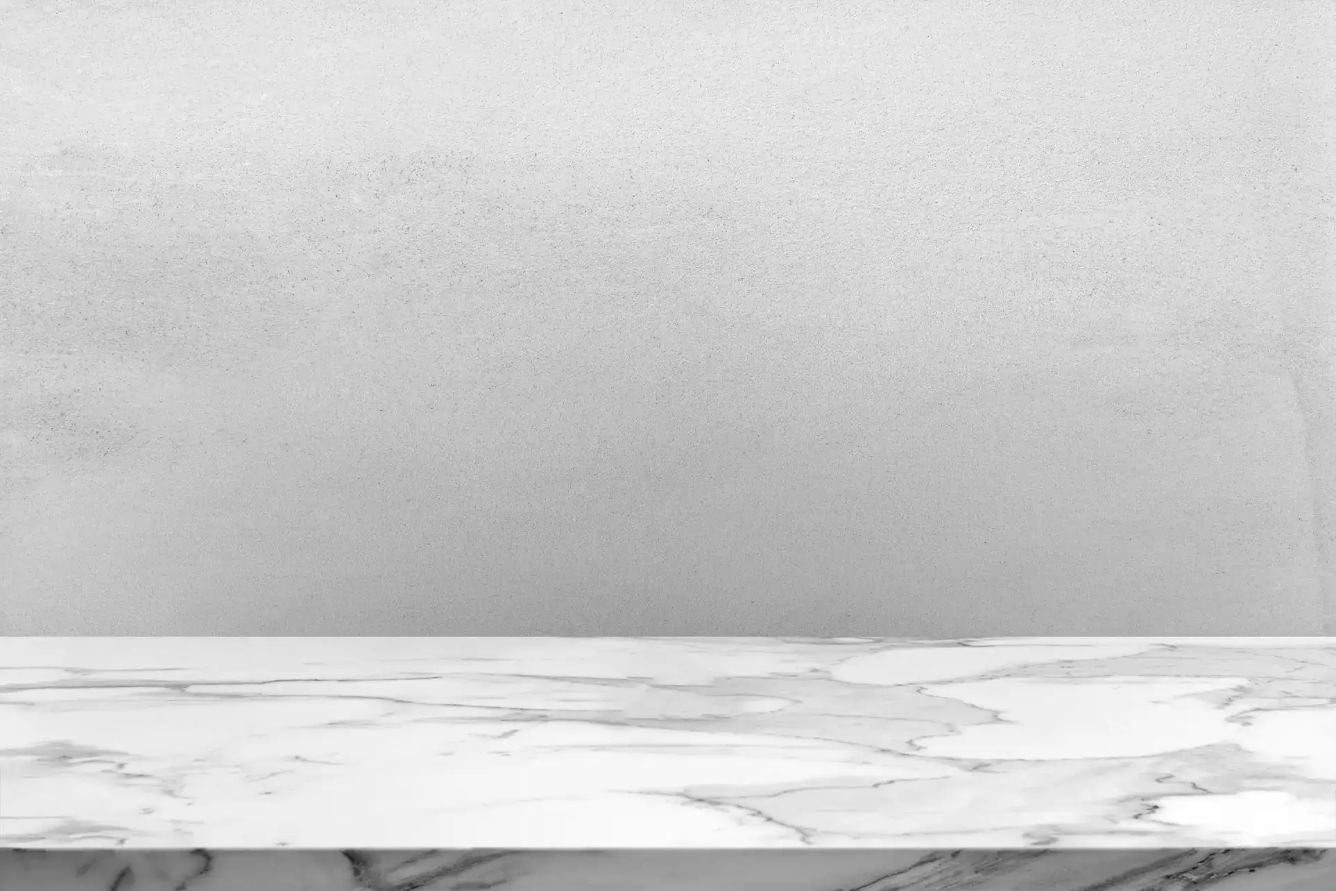 A clean, light gray textured wall stands behind a smooth white marble surface with subtle gray veining.